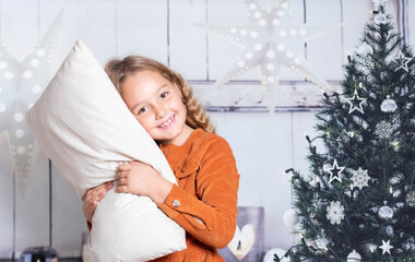 Little girl in red dress at home holding pillow on Christmas dates