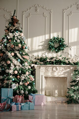 New Year's gifts in designer paper and bright ribbons under the Christmas tree on the floor on New Year's Eve. Christmas tree decorated with toys stands near the fireplace