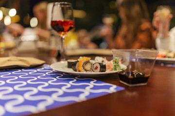 evening dinner in a restaurant, sushi and a glass of wine