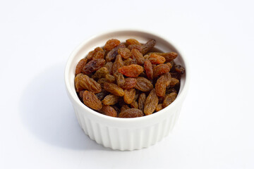Dried grape raisins in cup on white background