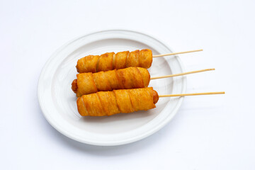 Fried dough snacks wrapped sausage on white background.