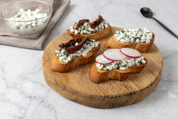 Crispy baguette with cottage cheese, herbs and garlic. Healthy breakfast.
