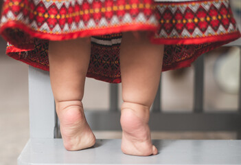 Child standing on tiptoes reaching out at the kitchen. One year old infant baby tiptoe closeup © tutye