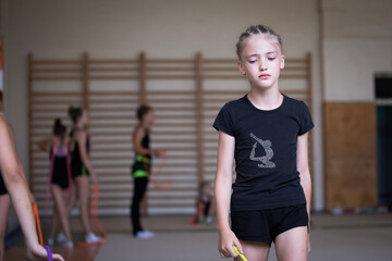 Portrait of upset and tired girl gymnast in gym on training