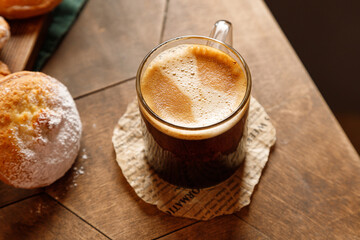 espresso coffee in a glass mug with cheesecake on a wooden background
