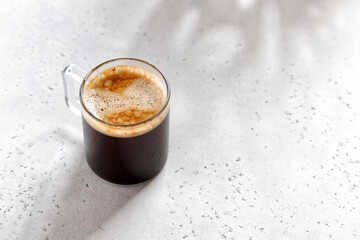 one espresso coffee in a glass mug on a light grey background