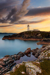 One of the most beautiful lighthouses, Fanad Head lighthouse, Ireland Donegal,  Fanad head at Donegal, Ireland with lighthouse at sunset. Colorful sky, mountains and sea 