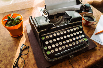 Old antique typewriter with inserted paper for writing articles and books on the desktop.
