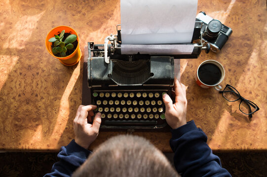 Male writer writing his book on an old antique typewriter. An old antique typewriter.