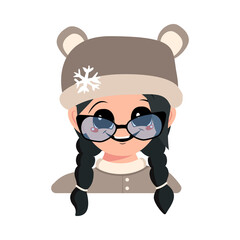 Girl with big eyes with glasses and wide smile and black hair in bear hat with snowflake. Cute child with happy expression in winter headdress. Head of adorable kid with emotions