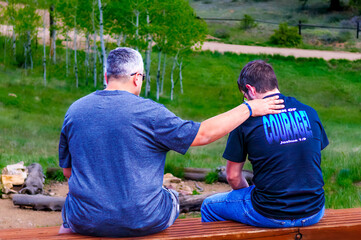 Men in the mountains praying together for courage and strength.