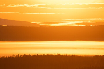 Beautiful fells in fog during a colorful morning in Northern Finland near Kuusamo in autumn.	