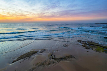 Aerial sunrise seascape with high cloud and gentle surf