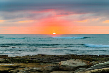 Sunrise seascape with rocky foreground