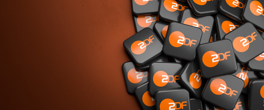 Logos of the German public-service television broadcaster  ZDF on a heap on a table. Copy space. Web banner format.