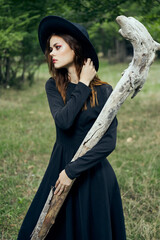 woman in black witch costume in forest nature posing