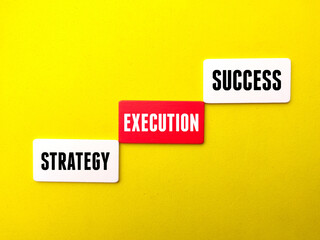 Colored cube written with text Startegy Execution Success on a yellow background.