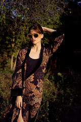 pretty woman in fashionable clothes sunglasses nature posing