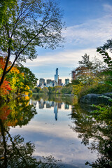 Fototapeta na wymiar Central Park lake with skyline reflection in the background, during fall season.