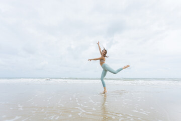 fitness, sport, and lifestyle concept - couple making yoga exercises on beach,  Man and woman doing yoga exercise on the beach.
