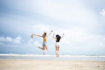 Obraz premium happy young woman jumping on the beach. woman jumping on the beach at the sea in the sunny day. Travel summer concept