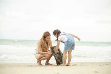 Asian family collecting plastic waste on the beach.  young people friends picking up trash and...