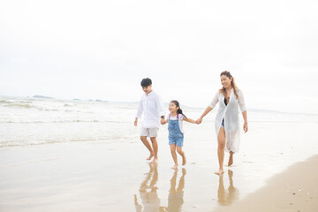 Fototapeta na wymiar Happy family having fun running on beach. Relaxing holiday concept. Travel attention