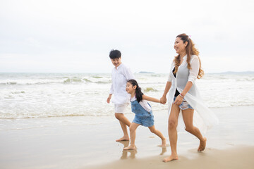 Happy family having fun running on beach. Relaxing holiday concept. Travel attention