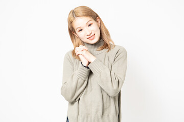 手を組んでお願いするセーターを着た女性