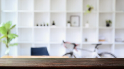 Empty wooden table with blurred bookshelf and trendy bicycle. For your product display montage.