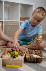 Touch drawer with rainbow rice inside. Children hand touch the texture. Montessori material concept for toddlers.