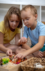 Touch drawer with rainbow rice inside. Children hand touch the texture. Montessori material concept for toddlers.