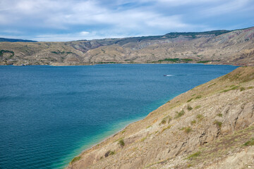 Fototapeta na wymiar Boat on the Sulak reservoir on a sunny day. Republic of Dagestan, Russia
