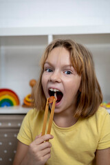 Girl are play and eating a toy snail with tongs. Education through the game concept.