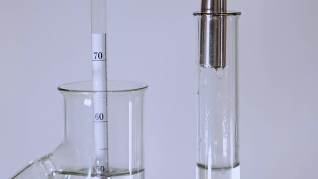 Home production of alcohol. Falling drops of alcohol fall into a special "parrot" flask with an alcohol meter floating in it.