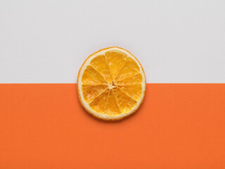 A piece of dried orange on a white and orange background.