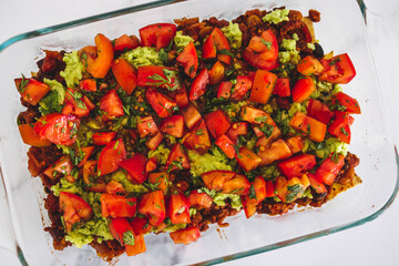 vegan vegan nachos with corn chips beans guacamole and fresh tomato salsa, healthy plant-based food