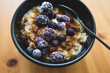vegan oatmeal with cinnamon ixed berries and maple syrup, healthy plant-based food