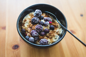 vegan oatmeal with cinnamon ixed berries and maple syrup, healthy plant-based food
