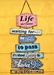 Life isn’t about. Wooden hanging signage sayings wall art home décor design on yellow wall