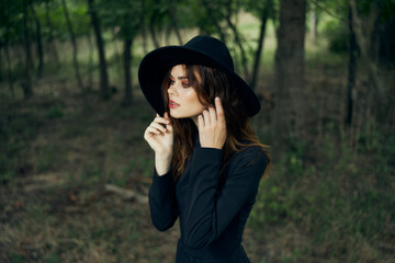 woman witch in black hat in the forest posing fantasy