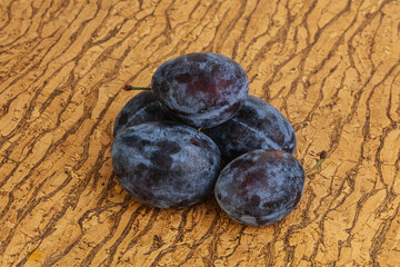 Ripe plum heap over background