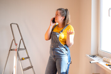 Tired frustrated woman doing a home renovation and talk on the phone. difficulties and problems...