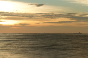 Naklejka na ściany i meble horizon from the seashore during golden hour in the evening