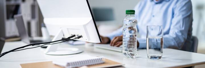 Water Bottle And Drinking Glass On Desk