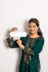 Young indian girl cheering while holding a sanitary pad in her hands and standing on a white isolated background.