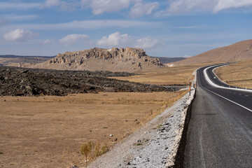 Fototapeta premium The lava flow stopped near a road passing through a mountainous area