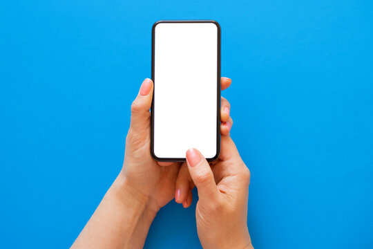 Mobile phone with blank white screen held in both hands on blue background