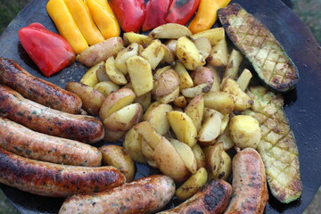 Fry meat with vegetables on the street. Delicious and unhealthy picnic food.