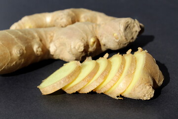 A useful product, ginger root lies on a black background.